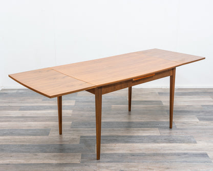 Esstisch, 60er Jahre, in Nussbaum, leichte Ellipsenform.